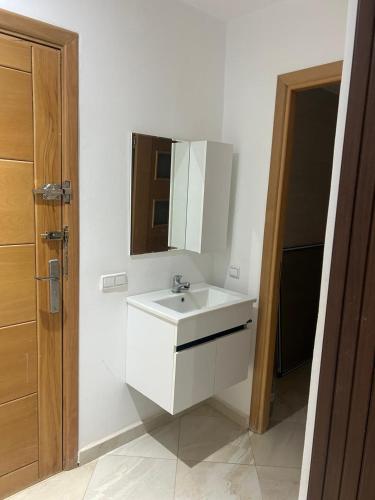 a bathroom with a white sink and a mirror at Comfort Stay Oujda in Oujda