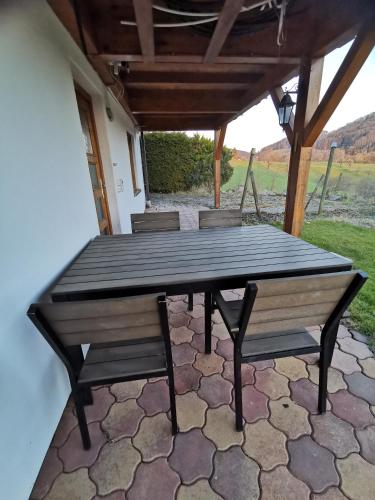 a wooden table and benches on a patio at Vreni's Gästezimmer in Himmelried