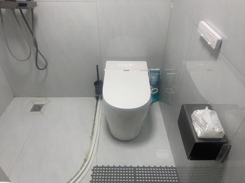 a small bathroom with a toilet and a trash can at Space Sharing Station in Guiyang