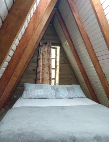 a bed in the middle of a attic at Guarda Garden Cabanas in Palhoça