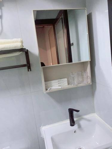 a bathroom with a sink and a mirror at Space Sharing Station in Guiyang