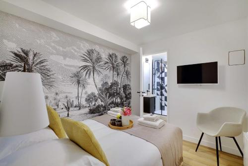 - une chambre avec un lit et une fresque murale de palmiers dans l'établissement Chic apartment - 2BR 6P - Saint-Ambroise, à Paris