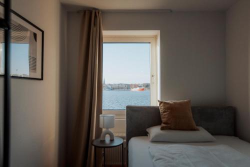 a bedroom with a window with a view of the water at Meerblick 8 - zwischen Haven und Meer in Wilhelmshaven