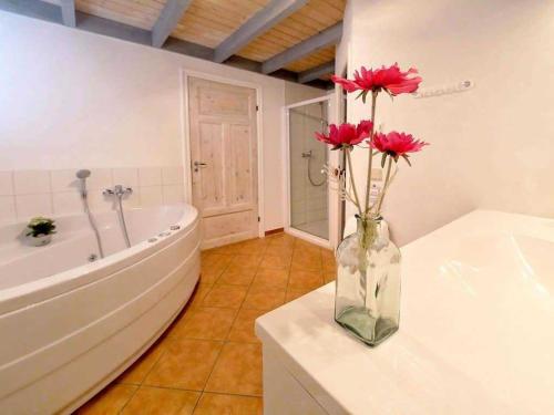 a bathroom with a vase with red flowers in it at Ferienpark Scharmützelsee in Wendisch Rietz
