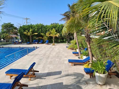 une rangée de chaises longues bleues à côté d'une piscine dans l'établissement Cartagena Beach Condo - 1400 sq. Ft. (130 m2), à Carthagène des Indes