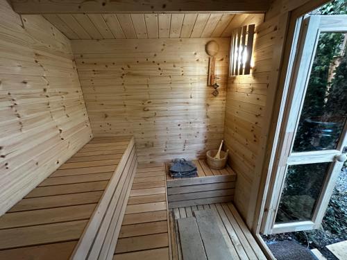 a wooden sauna with a window next to it at Retro Lodge nr Dartoor with hot tub & opt sauna in Newton Abbot
