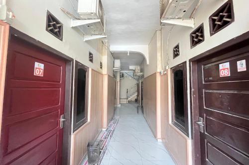 un couloir avec deux portes rouges et un couloir avec dans l'établissement Gratia Guesthouse, à Jambi