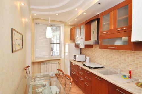 a kitchen with wooden cabinets and a sink and a window at Cheap Apartments in Kyiv