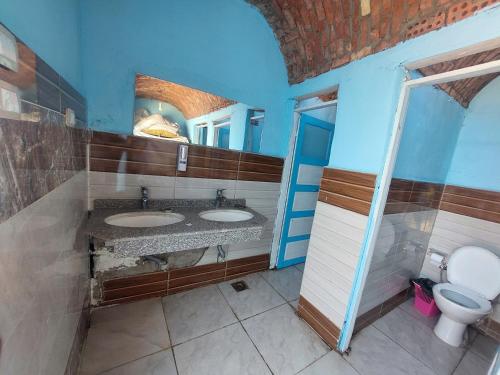 a bathroom with two sinks and a toilet at Mama Africa Camp in Luxor