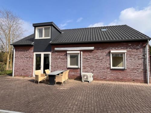 a brick house with a table and chairs in front of it at B&K het hoenveld in Driel