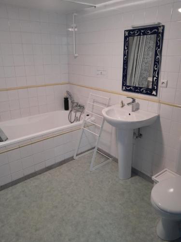 a bathroom with a sink and a tub and a toilet at Chez Marie-Angèle in Treignes