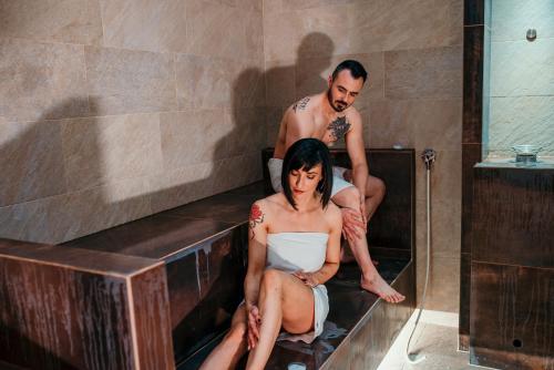 a man and a woman sitting in a bath tub at Belvedere Resort Hotels in Izola