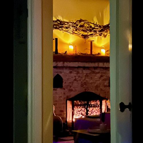 a room with a brick fireplace with a table and a mirror at 1890 CapeCod farmhouse:Charming, Private, Spacious in Saugerties
