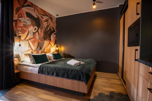 a bedroom with a bed with a painting on the wall at Ku Słońcu -Pokoje&Apartamenty - Jastrzębia Góra in Jastrzębia Góra