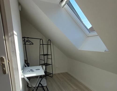 a attic room with a skylight and a ladder at Trois Studios-Cosy centre village in Brouckerque