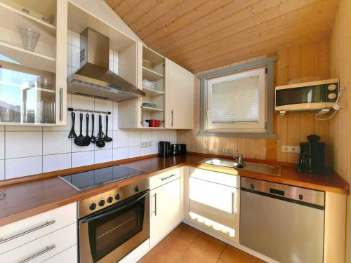 a kitchen with white cabinets and a sink at Ferienpark Scharmützelsee in Wendisch Rietz