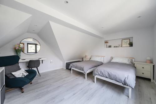 a bedroom with two beds and a desk and a mirror at Little Bay Trees, A Home Away from Home in Ifold