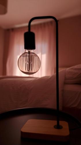 a lamp sitting on a table next to a bed at Albero in Alexandroupoli