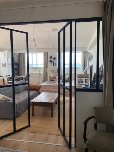 a living room with sliding glass doors and a table at Loctudy, les pieds dans l'eau in Loctudy