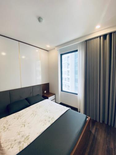 a bedroom with a large bed and a window at 7Homestay in Hai Phong