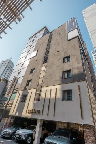 a building with cars parked in front of it at Hotel BELLUS in Busan