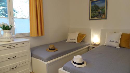 - 2 lits jumeaux dans une chambre avec des chapeaux dans l'établissement La maison d Oliver, à Gassin