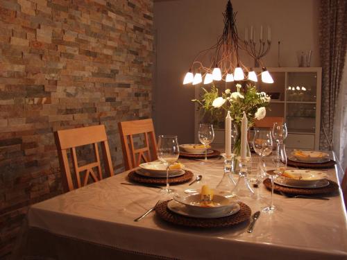 une table à manger avec un tissu de table blanc et des verres dans l'établissement La maison d Oliver, à Gassin