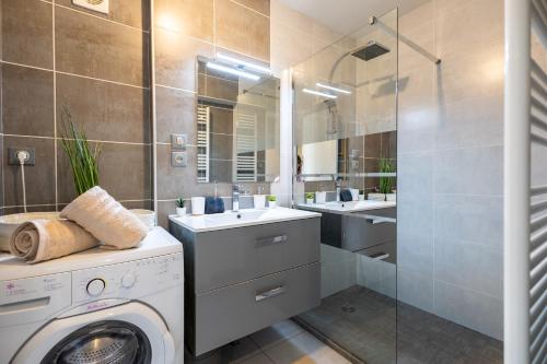 une salle de bain avec une machine à laver et un lavabo dans l'établissement Le Riviera - Front de mer, Terrasse, Parking privé, à Palavas-les-Flots