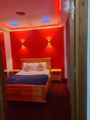 1 dormitorio con 1 cama con paredes y luces rojas en La Parenthèse, en Rabat