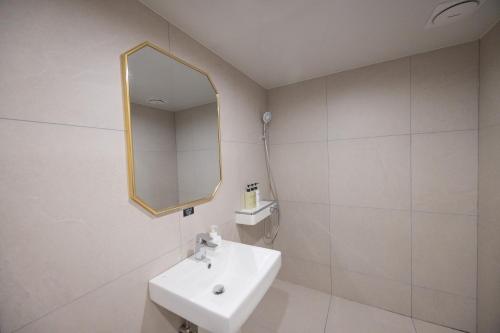 a bathroom with a sink and a mirror at Hotel BELLUS in Busan