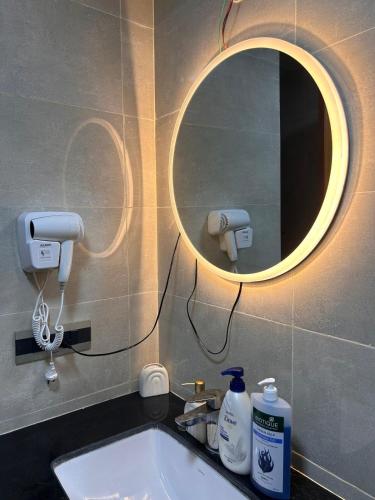 a bathroom with a sink and a mirror on the wall at Up in the Clouds Omaxe Hazratganj in Lucknow