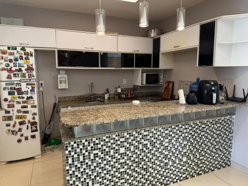 a kitchen with a black and white tile counter top at Big house 15 minutes to Belém for 6 people in Ananindeua