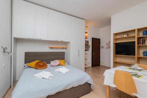 a bedroom with a bed with white cabinets and two chairs at Duomo di Pavia - Comodo bilocale in centro città in Pavia