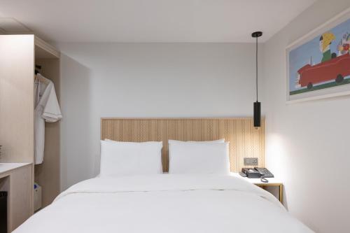 a bedroom with a large white bed in a room at Hotel BELLUS in Busan