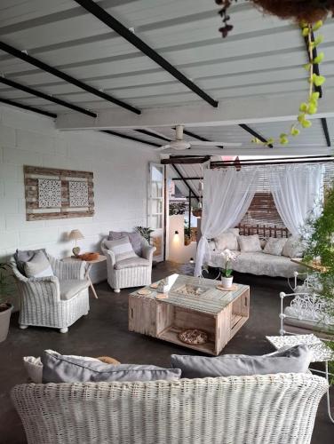 a living room with white couches and a coffee table at Kot Nou - Kwizine Mama Manze Lakaz in Mahébourg
