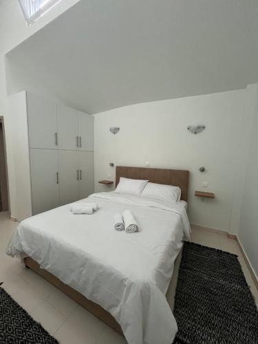 a bedroom with a white bed with towels on it at Jimilio 2 in Spáta