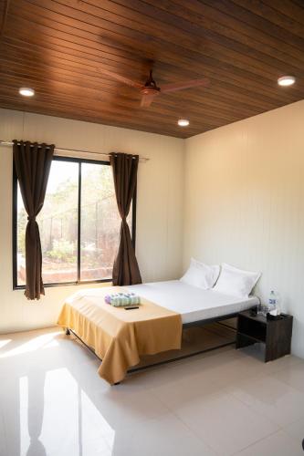 a bedroom with a bed with a wooden ceiling at Jungle Spring Resort in Ghātkar