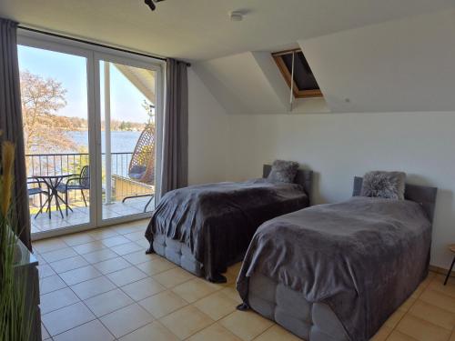ツォイテンにあるMonteurzimmer 1 mit Seeblickのベッドルーム1室(ベッド2台付)、景色を望むバルコニーが備わります。