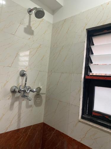 a shower in a bathroom with a stone wall at Jhochhen Rooms in Kathmandu