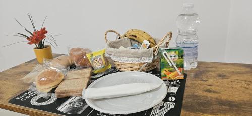 una mesa con un plato y una cesta de pan en ALOHA ROOM vicino all'aeroporto, en Bolonia