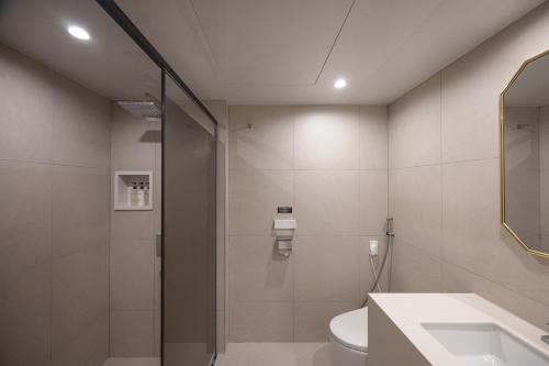 a bathroom with a shower and a toilet and a sink at Hotel BELLUS in Busan