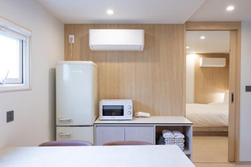 a kitchen with a refrigerator and a bed at Hotel BELLUS in Busan