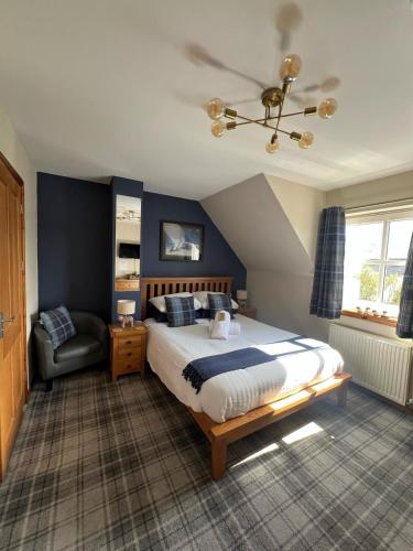 a bedroom with a king sized bed and a chair at Culacrick in Banavie