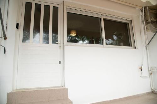 a white door with a group of dogs sitting in a window at Paradise Tolo Psili Ammos in Tolo