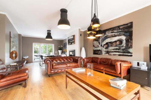 a living room with leather couches and a table at Exquisite Townhouse in Lisbon City Center- PRIVATE GARAGE & TERRACE in Lisbon
