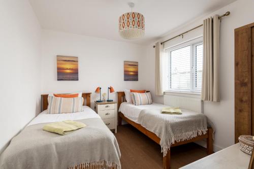 a bedroom with two beds and a window at Beach Retreat in Whitstable