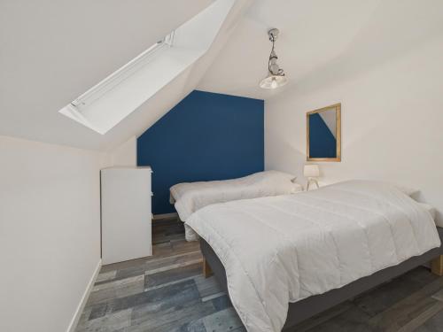 une chambre avec deux lits et un mur bleu dans l'établissement Maison pour 4 avec jardin a 500m de la plage, à Piriac-sur-Mer