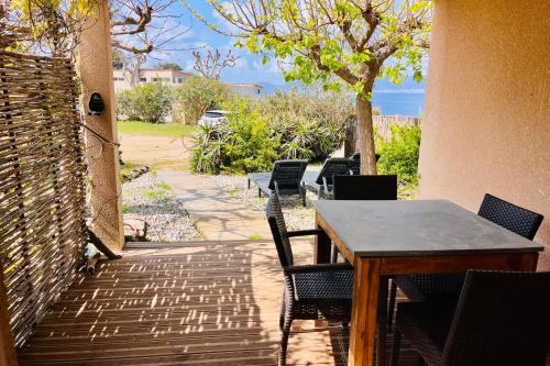 un tavolo e sedie su un patio con vista sull'oceano di Sabali - Cottage Plage d'Argent at 100m - by TGB a Coti-Chiavari