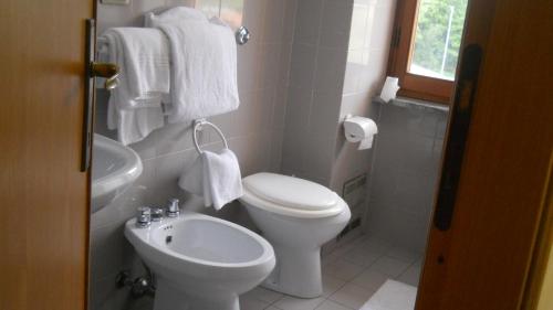 a white bathroom with a toilet and a sink at Hotel Diana in Cassino