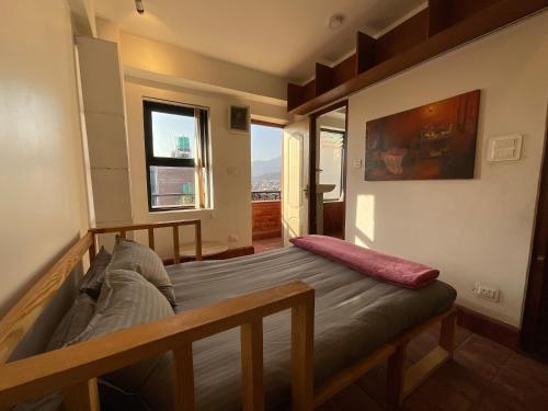 a bedroom with a bed and a large window at Tehra Family Building in Kathmandu